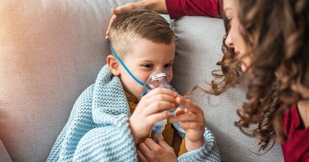 Niño con respirador en la nariz acompañado de su mamá